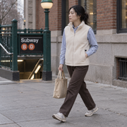 Woman wearing the cream heated fleece vest during a city commute